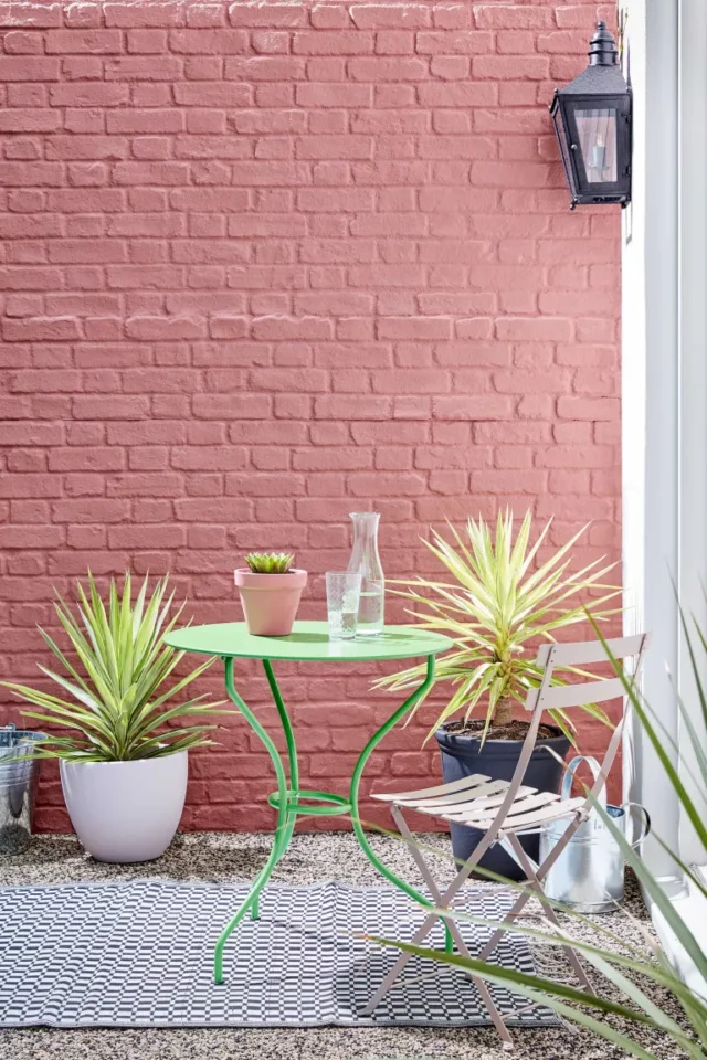 consigli dell'esperto per progettare un piccolo giardino: set bistrot contro il muro rosa