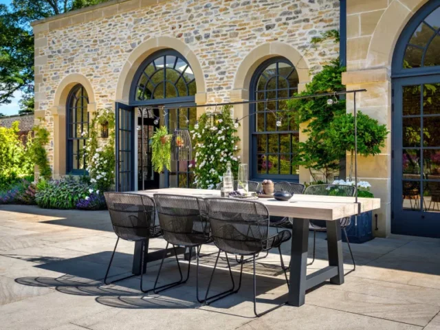 idee arredo giardino: tavolo con luci a festoni nel patio