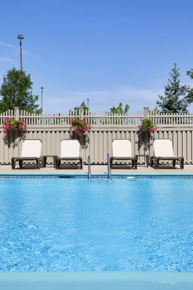 idee di recinzione per piscina: sedie a sdraio accanto alla piscina