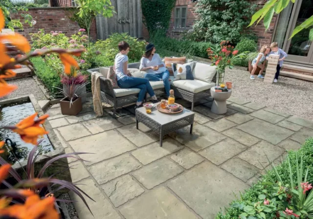 idee eco patio con eco pavimentazione bradstone con famiglia seduta su mobili da esterno