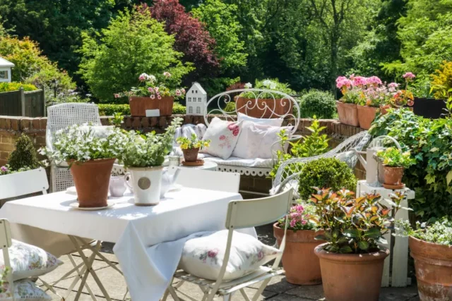 idee per il giardinaggio nel patio: piante in vaso intorno ai posti a sedere nel patio