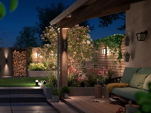 luci a parete in un giardino moderno con un divano all'aperto, decking e recinzioni a pannelli